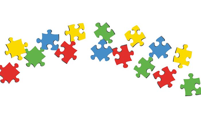 Red, yellow, green, and blue puzzle pieces in an arch on white background