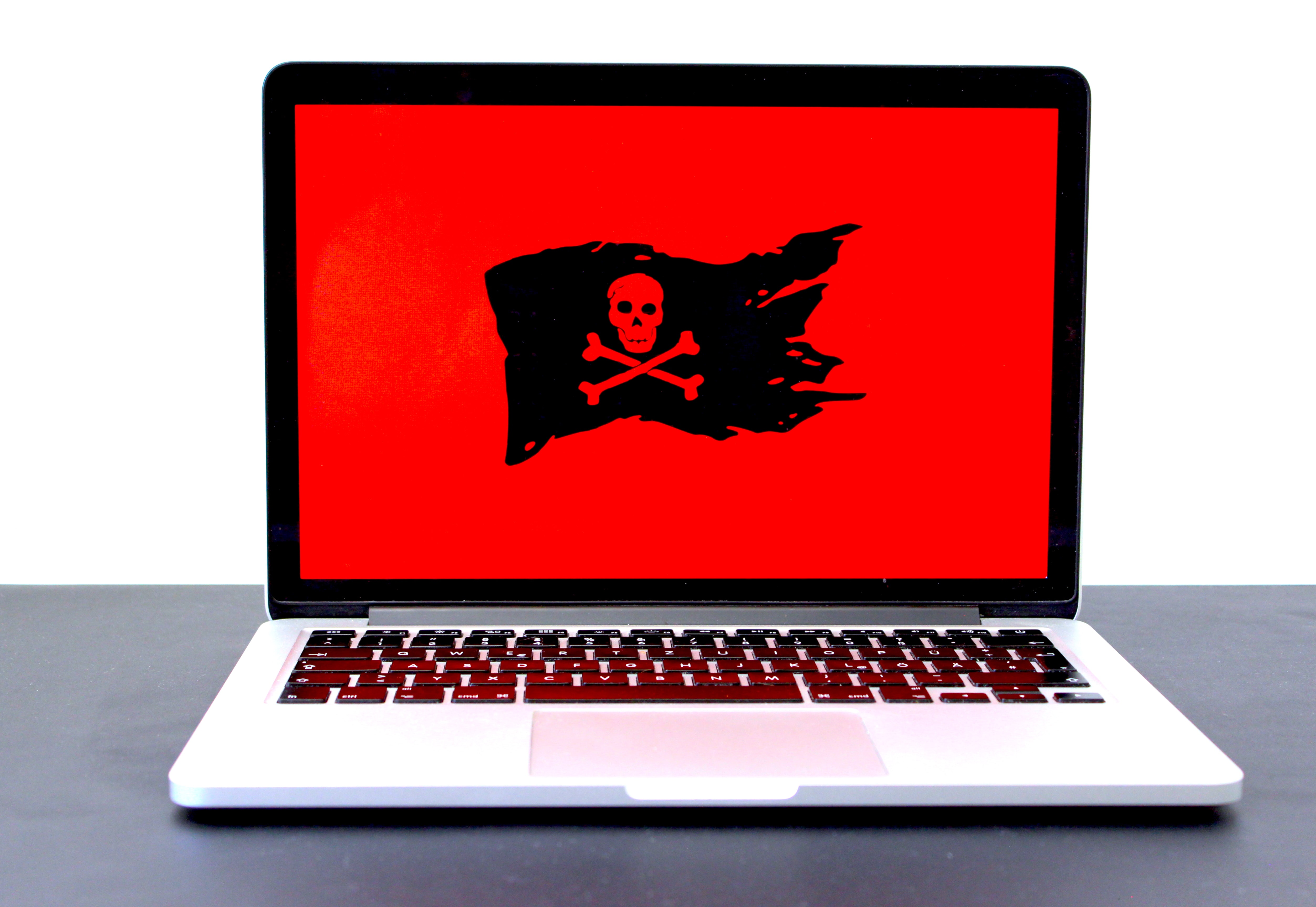 Laptop with red screen and skull and cross bones flag