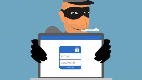 Stop_Getting_FB_Hacked_1340px.jpg Masked Thief with Key in Mouth Holding Laptop