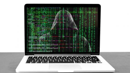 hacker-5332676_1280.jpg Laptop with hooded figure on screen with matrix like green code over top